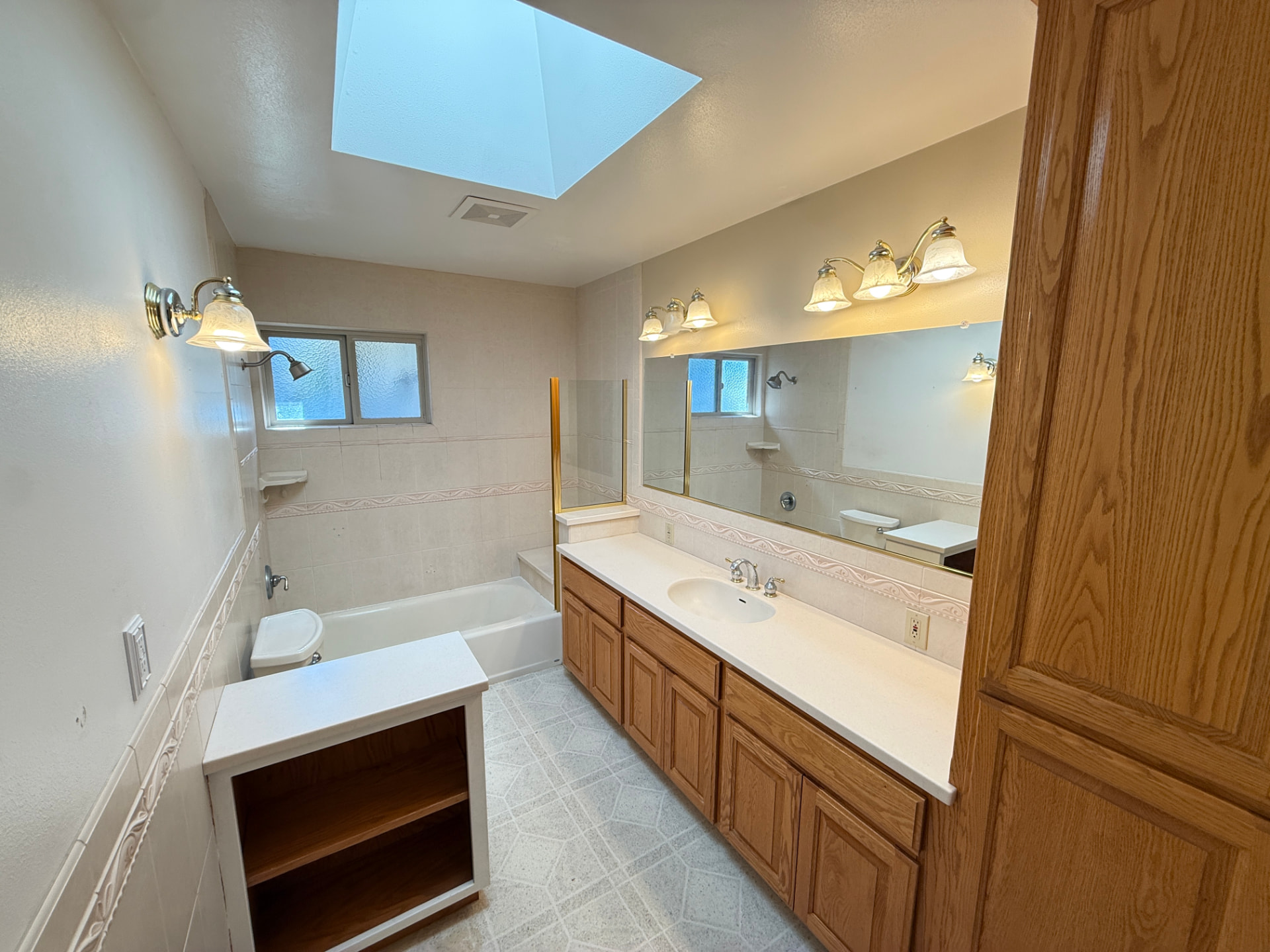 Bathroom before The House Doctor remodel with oak cabinets and an old tub