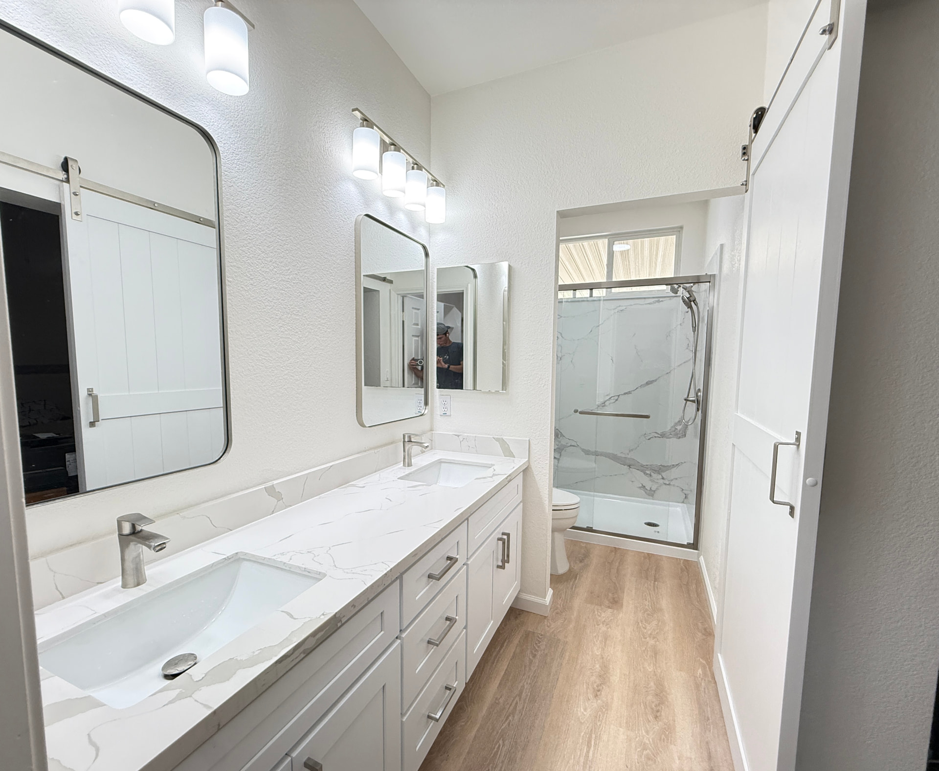 House Doctor bathroom remodel with a long marble-look vanity and glass shower